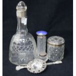 A George V silver topped decanter by Asprey & Co, an enamel topped bottle and three other items.
