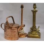 A brass table lamp, a copper table lamp and a watering can