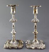 A pair of George III embossed silver candlesticks by James Stamp and John Baker, with waisted