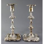 A pair of George III embossed silver candlesticks by James Stamp and John Baker, with waisted