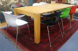 A Heals oiled oak extending dining table and eight various coloured plastic Eames style chairs, W.