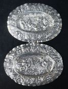 A pair of late 18th century Augsburg small silver oval plaques, embossed with cherubs, masks and
