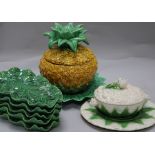 A Majolica cauliflower tureen, green leaf plates and pineapple bowl and cover