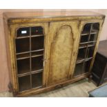 A walnut display cabinet enclosed by glazed and panelled doors, H.122cm
