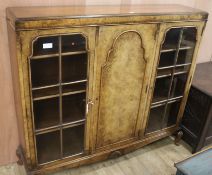 A walnut display cabinet enclosed by glazed and panelled doors, H.122cm