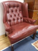 A leather button back wing armchair