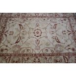 An fawn ground rug and a Persian red ground runner, 240 x 172cm and 250 x 62cm