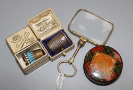 A gold plated magnifying glass, a silver gilt and enamel thimble, another thimble and a tartanware