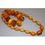 A single strand graduated oval amber bead necklace with spacers and an amber bead bracelet, gross