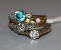 An 18ct gold, blue zircon and diamond three stone ring and two other diamond rings, one 18ct and one