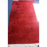 A Chinese red ground carpet, 220 x 120cm
