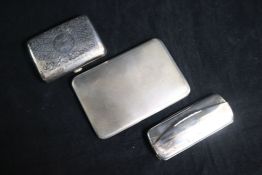 Two silver cigarette cases and a silver spectacles case.