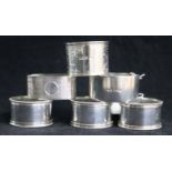 Three silver napkin rings and three plated napkin rings.