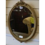 An oval giltwood and gesso framed wall mirror, H.58cm