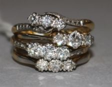 Four mid 20th century 18ct gold and three stone diamond rings.