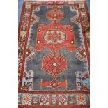 A Persian blue ground rug, woven with red geometric panels 200cm by 136cm