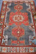 A Persian blue ground rug, woven with red geometric panels 200cm by 136cm