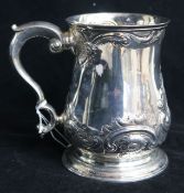 An early George III silver mug with later embossed decoration and later inscription to the base,