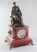 A 19th century French bronze and rouge marble mantel clock, surmounted with the figure of a seated