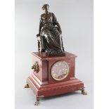 A 19th century French bronze and rouge marble mantel clock, surmounted with the figure of a seated