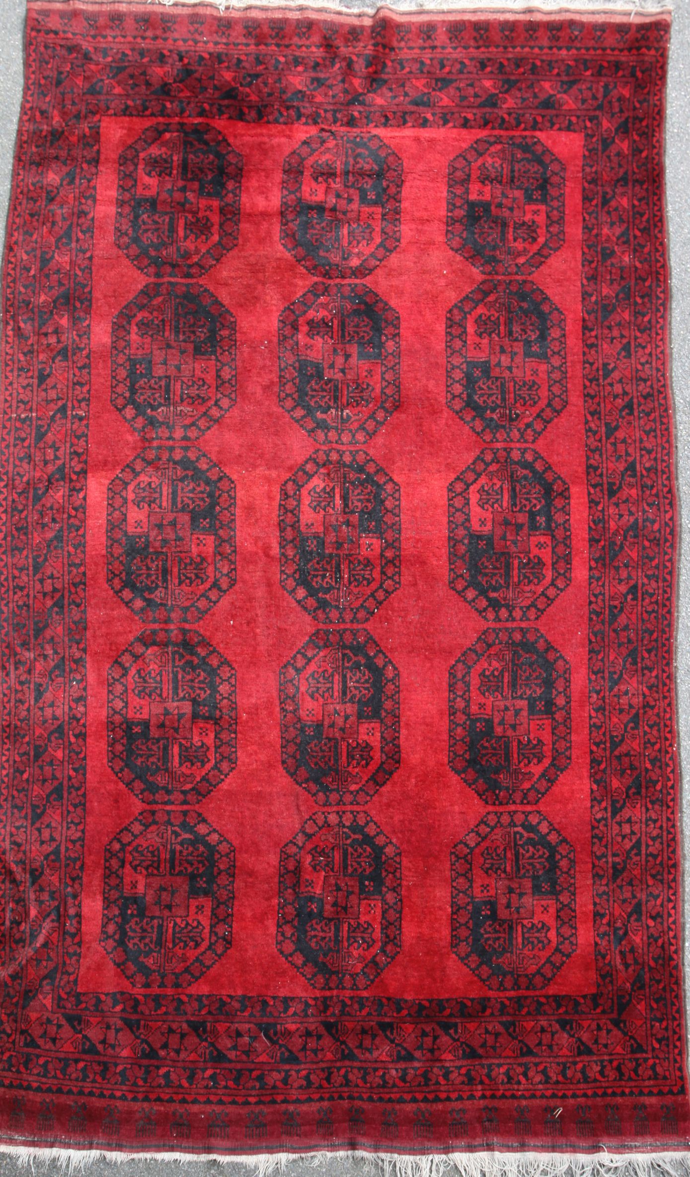 A North West Persian red ground carpet, with field of fifteen octagons, 12ft 3in by 7ft 9in.