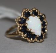 A yellow metal, white opal and sapphire cluster dress ring, size O.
