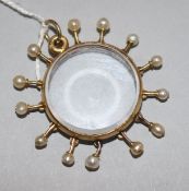 A gold and seed pearl mounted glazed sunburst pendant locket, 37mm.