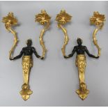 A pair of Louis XV style patinated and gilt bronze two-light figural Nubian wall sconces