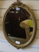An oval giltwood and gesso framed wall mirror, H.58cm