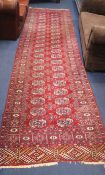A Bokhara red ground runner, woven with two rows of elephants foot, 380cm x 95cm