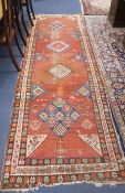 A Karabagh runner, woven with four lozenge medallions on a wine red ground with triple border, (