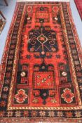 A Persian red ground rug, 255 by 132cm