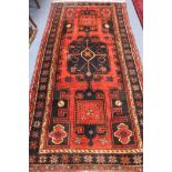 A Persian red ground rug, 255 by 132cm