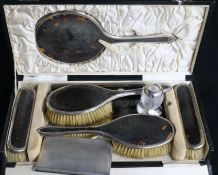 A 1920's cased silver and tortoiseshell six piece brush and mirror set, an aide memoire, a silver