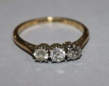 A 1930's 18ct gold and platinum three stone diamond ring, size M.