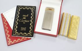 Three Must De Cartier lighters including two gold plated and one with box.