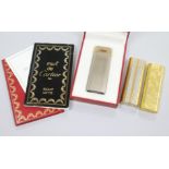 Three Must De Cartier lighters including two gold plated and one with box.