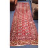 A Bokhara red ground runner, woven with two rows of elephants foot, 380cm x 95cm