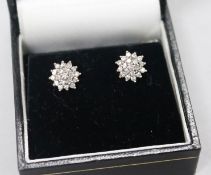 A pair of 9ct white gold and diamond cluster earrings,