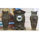 An ornate brass clock garniture