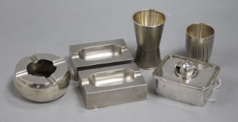 A pair of white metal ashtrays, a spirit measure and three other items