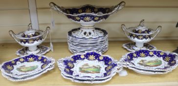 A Staffordshire dessert service, decorated in cobalt blue and gilt and painted topographical scenes,