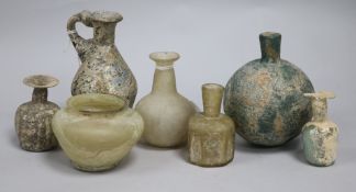 A collection of seven small Romano-Persian glass vessels including a bottle-shaped flask, a flask
