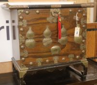 A Korean brass-mounted carved hardwood tansu, having curved moulded top over a shallow upper