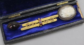 A Victorian gold, ruby and sapphire bar brooch and two stick pins