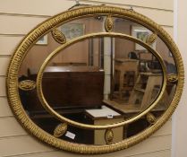 An Edwardian oval gilt gesso marginal framed wall mirror, W.110cm