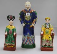 A pair of Chinese polychrome pottery figures, seated Emperor and Empress, and another of an official