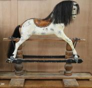 A Victorian painted carved wood rocking horse, with brass studded leather saddle, in trestle frame