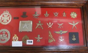 A framed collection of military badges