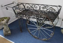 A wrought iron wheelbarrow planter, W.170cm